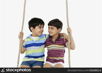 Portrait of boys sitting on a swing