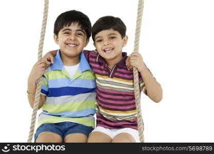 Portrait of boys sitting on a swing