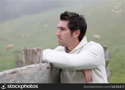 Portrait of breeder leaning on fence