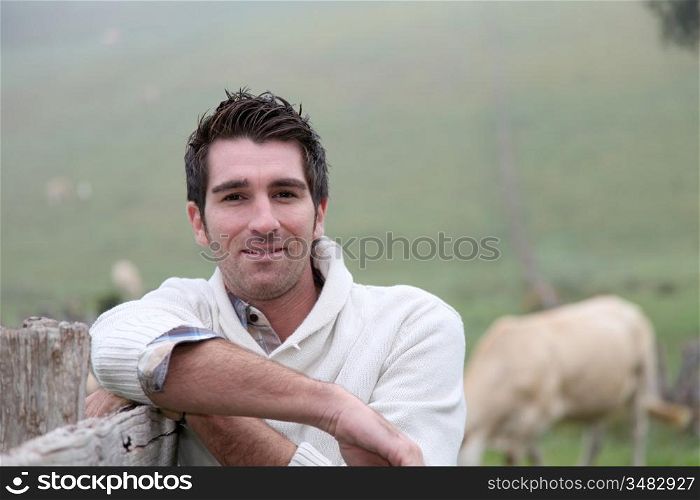 Portrait of breeder leaning on fence
