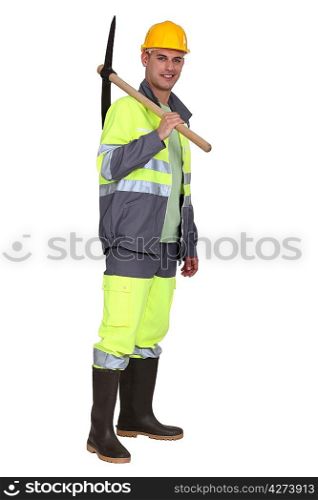 portrait of bricklayer standing with pickaxe over his shoulder