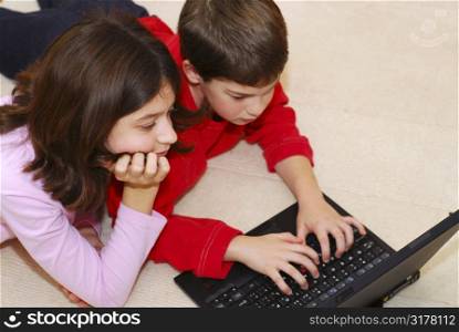 Portrait of brother and sister looking into computer