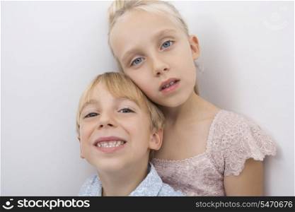 Portrait of brother and sister over gray background
