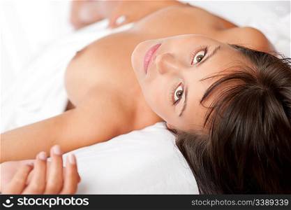 Portrait of brown hair naked woman in white bed, shallow DOF