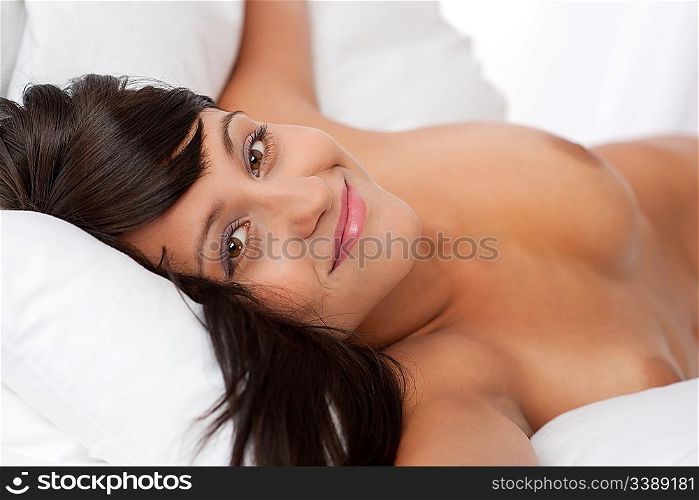 Portrait of brown hair naked woman in white bed, shallow DOF, focus on left eye