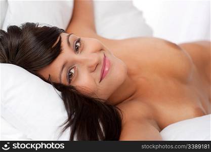 Portrait of brown hair naked woman in white bed, shallow DOF, focus on left eye