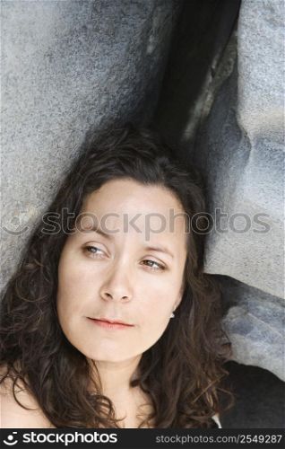 Portrait of brunette Caucasian mid-adult woman by rock formation.