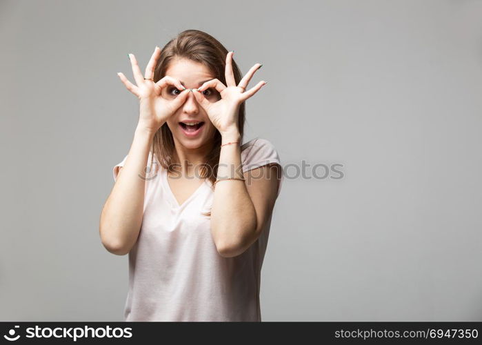 Portrait of brunette woman showing ok sign on eyes. Portrait of brunette woman showing ok sign on eyes.