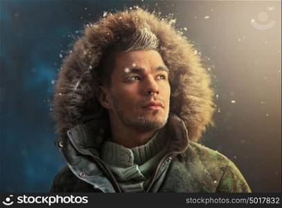 Portrait of brutal sexy man outdoors in winter under snowstorm