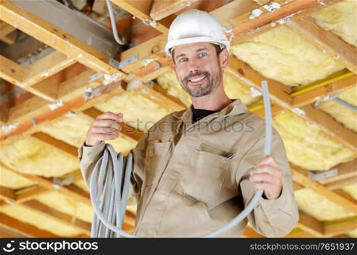 portrait of builder with reel of grey cable