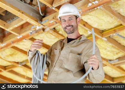 portrait of builder with reel of grey cable
