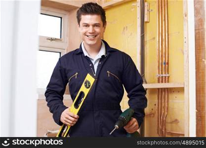 Portrait Of Builder With Spirit Level And Electric Drill