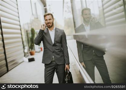 Portrait of businassman uses mobile phone outdoor