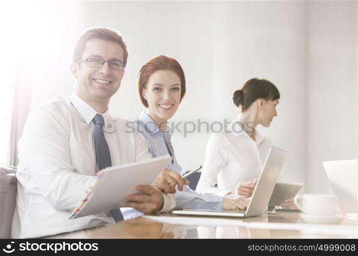 Portrait of business colleagues working at table in boardroom