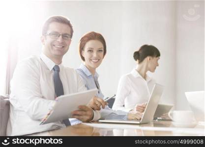 Portrait of business colleagues working at table in boardroom