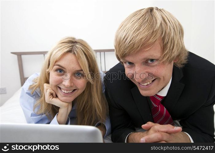 Portrait of business couple lying on bed