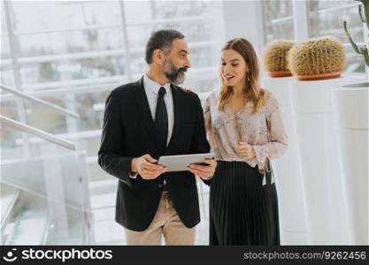 Portrait of business couple with digital tablet in office