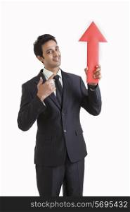 Portrait of business executive holding arrow sign