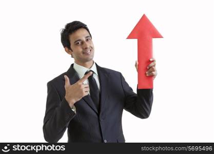 Portrait of business executive holding arrow sign
