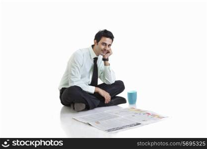 Portrait of business executive sitting with newspaper