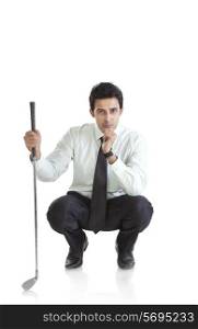 Portrait of business executive with golf club thinking