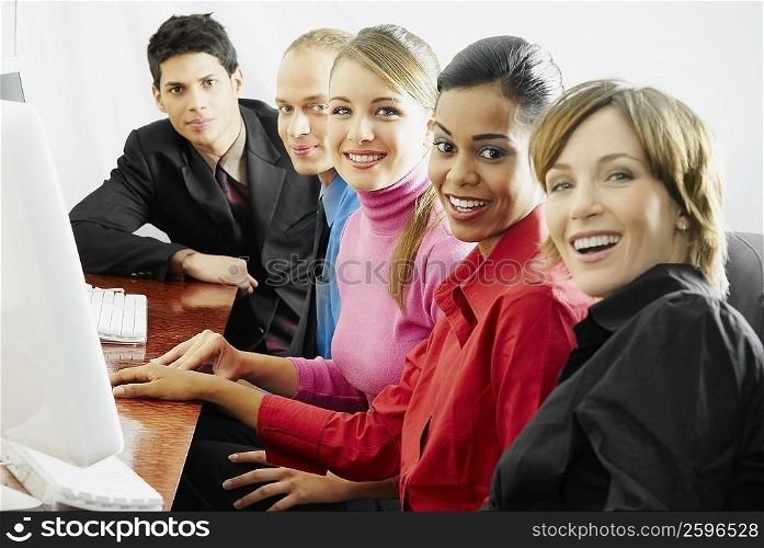 Portrait of business executives sitting in front of a computer