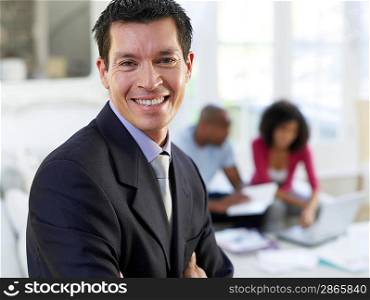 Portrait of business man in living room couple sitting in background