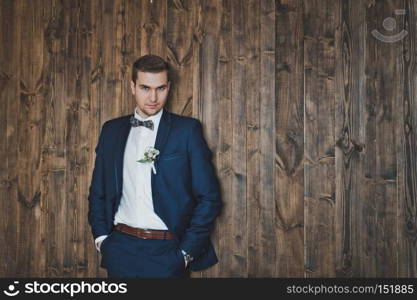 Portrait of business men in the background, the wooden walls of the Studio.. Portrait of a man in full growth 6432.