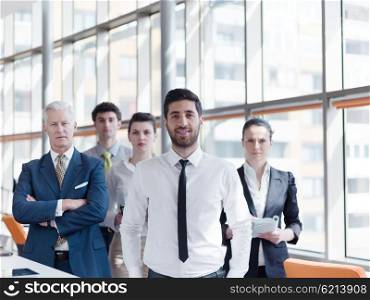 portrait of business people group at modern bright office, young arab man with beard standing in front as leader