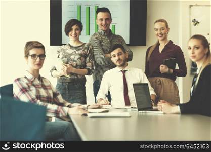 portrait of business people group at modern bright startup office meeting room, young man with beard sitting in middle as team leader