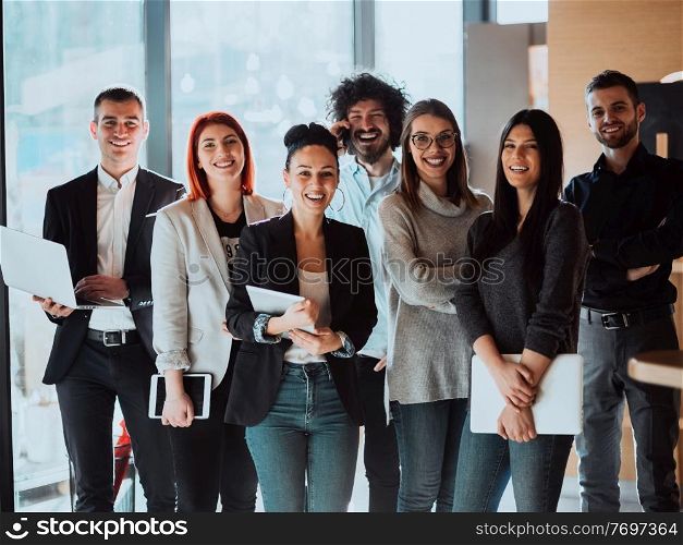 Portrait of Business team Standing in Modern Office on training in modern Office. Modern coworking startup open space office. High quality photo. Young Smiling Managers Standing in Modern Office. Training in Office. Modern Office Concept. Woman in White Shirt. Man in Black Suit.