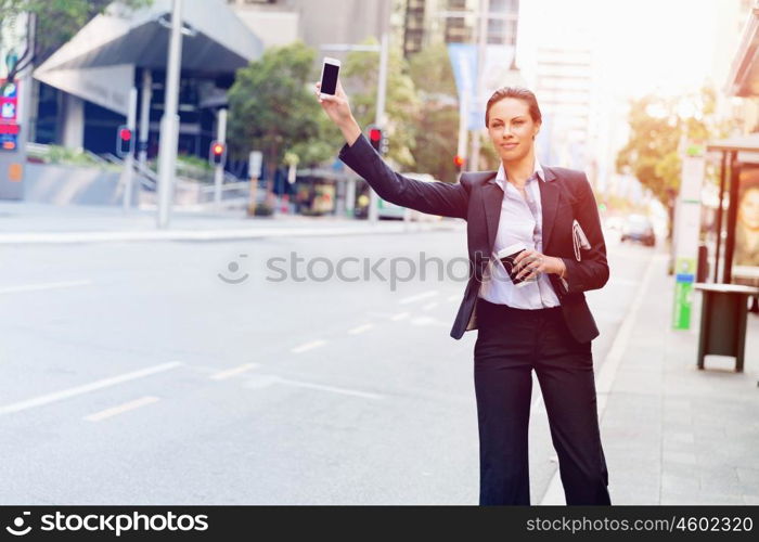 Portrait of business woman catching taxi. Portrait of young business woman catching taxi in city