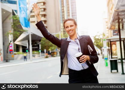 Portrait of business woman catching taxi. Portrait of young business woman catching taxi in city