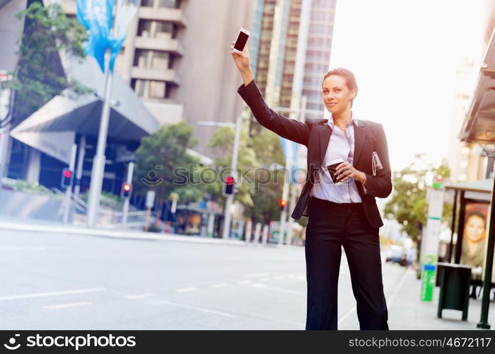 Portrait of business woman catching taxi. Portrait of young business woman catching taxi in city