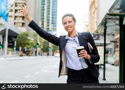 Portrait of business woman catching taxi. Portrait of young business woman catching taxi in city