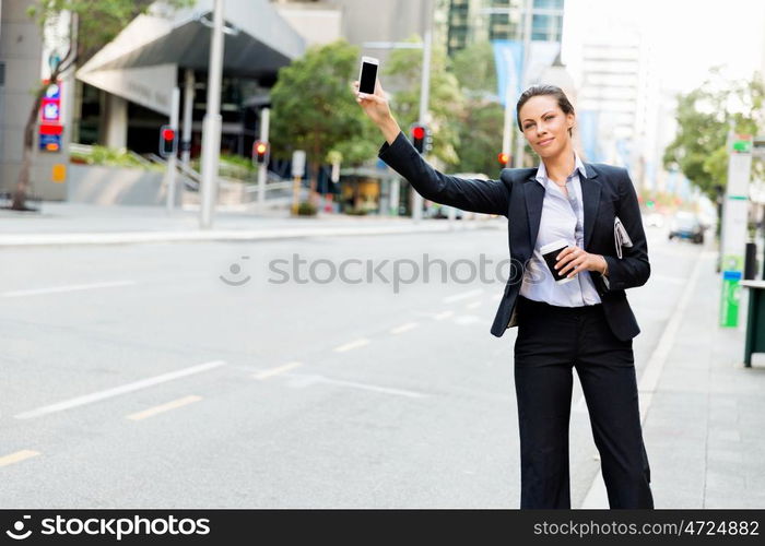 Portrait of business woman catching taxi. Portrait of young business woman catching taxi in city