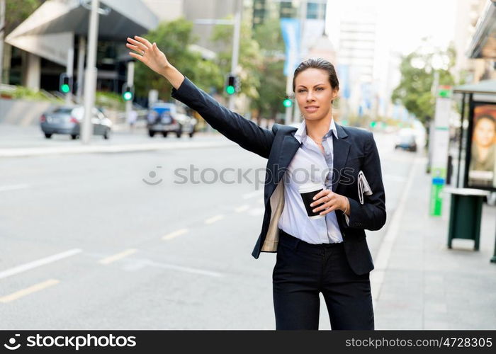 Portrait of business woman catching taxi. Portrait of young business woman catching taxi in city