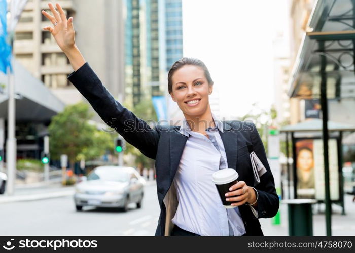 Portrait of business woman catching taxi. Portrait of young business woman catching taxi in city