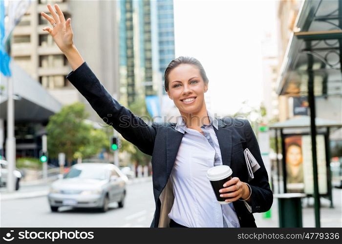 Portrait of business woman catching taxi. Portrait of young business woman catching taxi in city