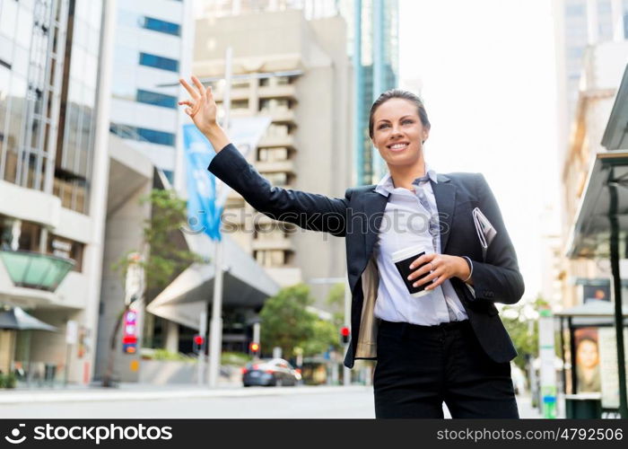 Portrait of business woman catching taxi. Portrait of young business woman catching taxi in city