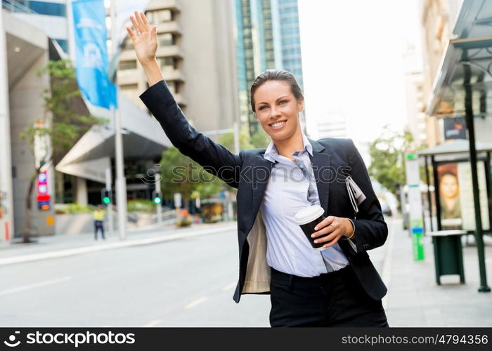 Portrait of business woman catching taxi. Portrait of young business woman catching taxi in city