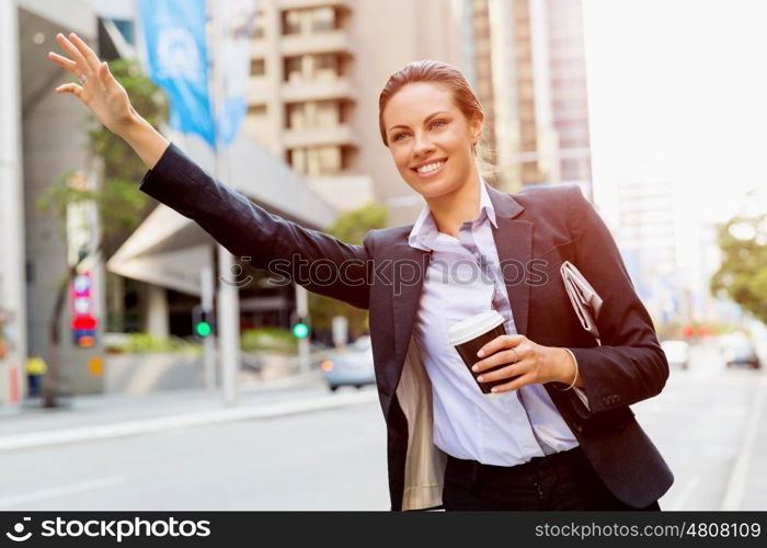 Portrait of business woman catching taxi. Portrait of young business woman catching taxi in city