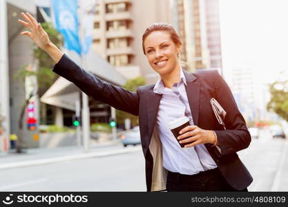 Portrait of business woman catching taxi. Portrait of young business woman catching taxi in city