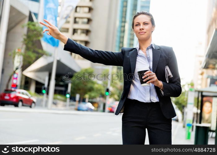 Portrait of business woman catching taxi. Portrait of young business woman catching taxi in city