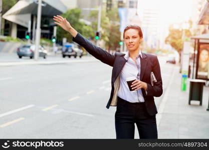 Portrait of business woman catching taxi. Portrait of young business woman catching taxi in city