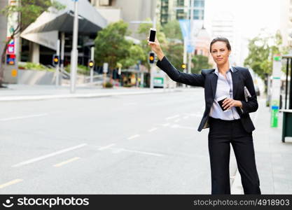 Portrait of business woman catching taxi. Portrait of young business woman catching taxi in city