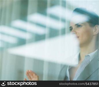 Portrait of business woman looking in window