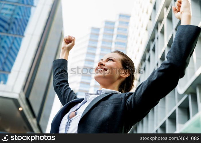 Portrait of business woman smiling outdoor. Portrait of young business woman outdoors with arms raised up