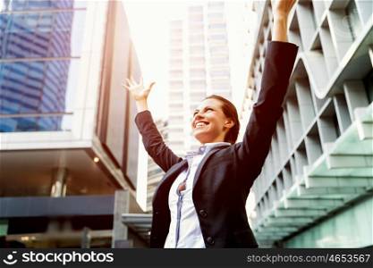 Portrait of business woman smiling outdoor. Portrait of young business woman outdoors with arms raised up