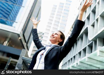 Portrait of business woman smiling outdoor. Portrait of young business woman outdoors with arms raised up